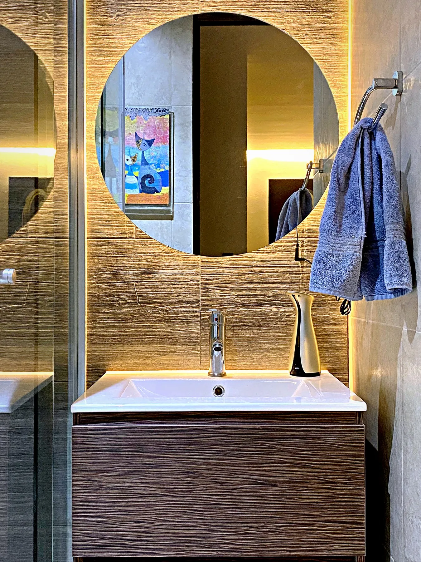 Espejo redondo con luz indirecta en baño