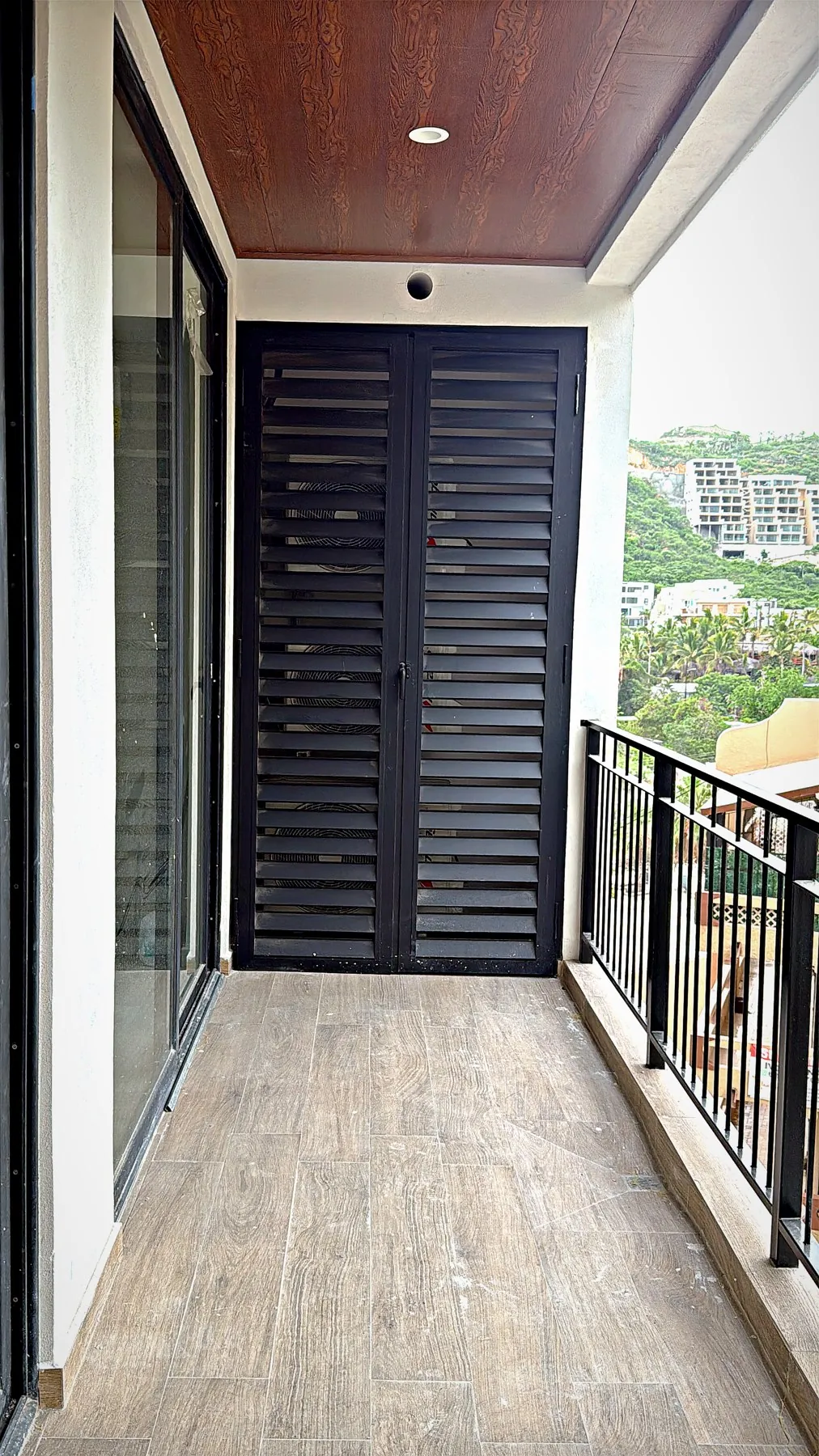 Puerta con celosía de aluminio en terraza de departamento