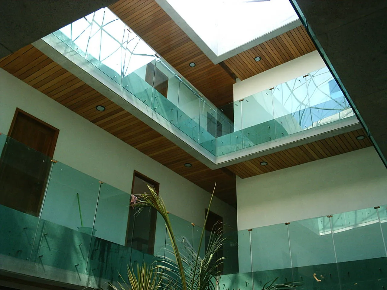 Cubierta de cristal sobre patio interior con madera
